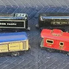 Collection of vintage Marx O-gauge lithographed tin toy train cars, including Union Pacific and New York Central models, showing moderate...