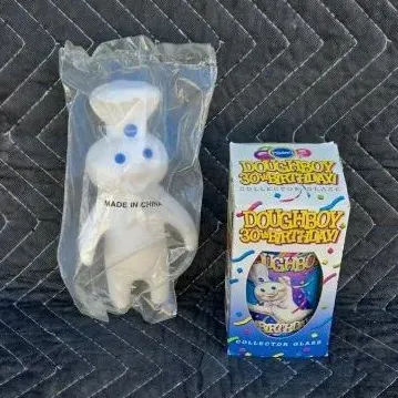 Pillsbury Doughboy 30th Birthday collector glass in its original box, paired with a sealed vinyl Doughboy figure.