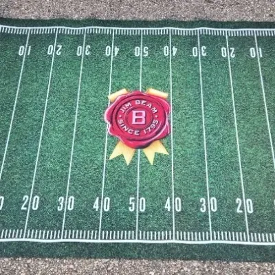 Jim Beam branded football field mat, featuring the brand's signature red wax seal logo at the 50-yard line and end zone graphics.