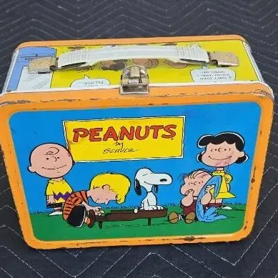 Vintage 1970s Peanuts metal lunchbox by King-Seeley Thermos Co., featuring Charlie Brown, Snoopy, and the gang with some visible edge...