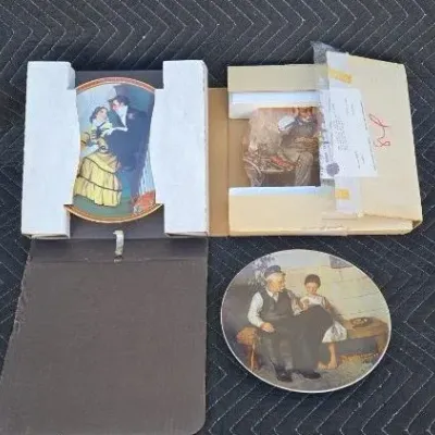 Norman Rockwell collector plates, including "The Toy Maker" and "The Cobbler," shown with their original boxes and...