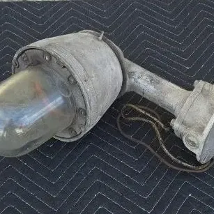 Vintage industrial explosion-proof light fixture with a heavy cast metal body and thick glass dome.
