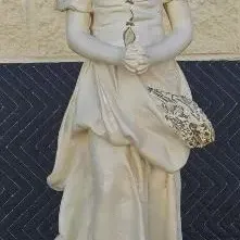 Vintage cast stone garden statue depicting a young woman in a headscarf and long dress, holding her hands together in prayer.