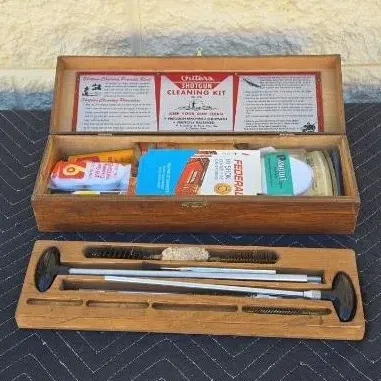 Vintage Outers shotgun cleaning kit housed in its original wooden box, complete with cleaning rods, brushes, patches, and instructional...