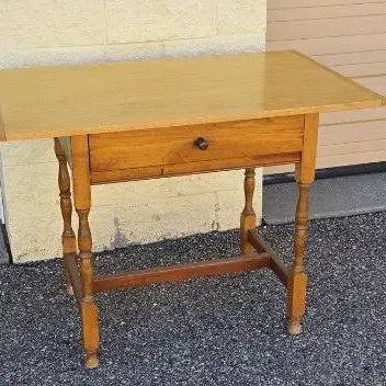 Vintage maple library table or writing desk featuring a single drawer with a wooden knob, turned legs, and an H-stretcher base.