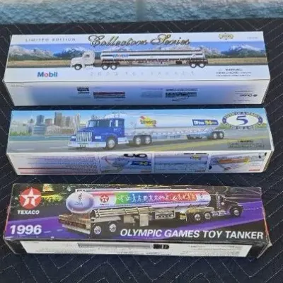 Three collectible toy tanker trucks in their original boxes, including a 2000 Mobil Collectors Series, a Sunoco Ultra 94, and a 1996...
