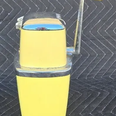 Vintage Rival Ice-O-Mat hand-crank ice crusher in pale yellow with chrome trim, circa 1950s.