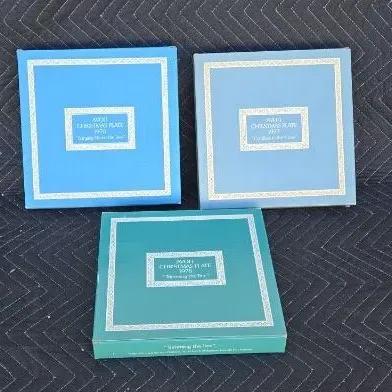 Three vintage Avon Christmas plates in their original boxes, including the 1976, 1977, and 1978 editions.
