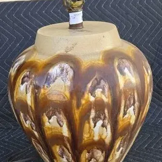 Mid-century modern ceramic table lamp base featuring a drip glaze in shades of brown, tan, and white, shown without a shade.