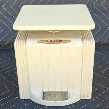 Vintage Universal cream-colored metal kitchen scale with Art Deco ribbed detailing and a 24-pound capacity dial.