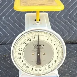 Vintage Hanson Model 1308 utility scale with a white metal body and a yellow top platform, featuring a 25-pound capacity dial.