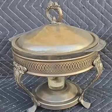 Vintage silver-plated chafing dish featuring an ornate reticulated stand with scroll feet and a matching domed lid.