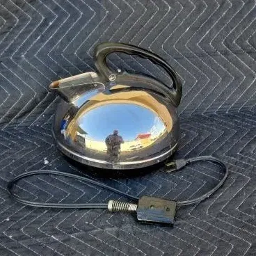 Vintage mid-century electric kettle with a polished chrome dome body, black plastic handle, and detachable power cord.