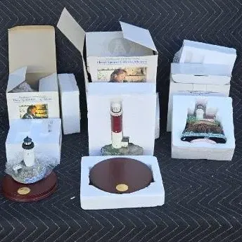 Collection of Harbour Lights lighthouse figurines, including the Cape Hatteras and Boston Harbor models, shown with their original boxes...