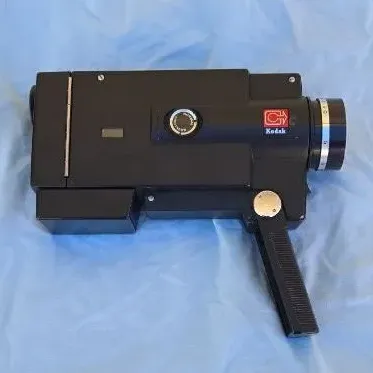 Vintage Kodak Super 8 movie camera with a black plastic body and pistol grip handle, circa 1970s.