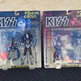 Two vintage KISS Psycho Circus action figures in original blister packaging, featuring Ace Frehley as "The Stiltman" and Gene...