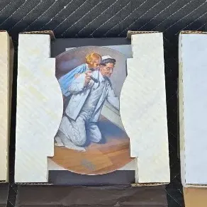 Three Norman Rockwell collector plates in their original cardboard packaging, featuring classic illustrated scenes.