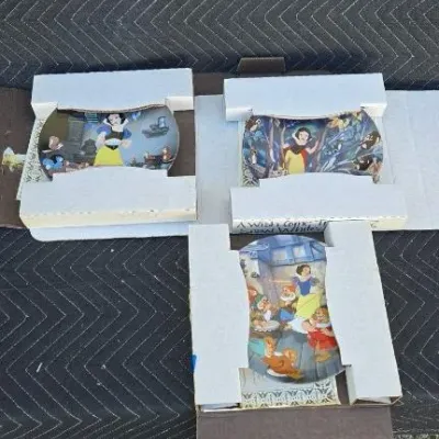 Three Disney Snow White and the Seven Dwarfs collectible plates, each housed in its original styrofoam packaging.