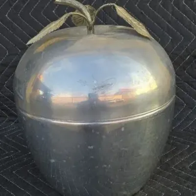 Vintage mid-century aluminum apple-shaped ice bucket featuring a brass stem and leaves.