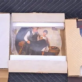 Three vintage Norman Rockwell collector plates, each housed in its original cardboard and styrofoam packaging.