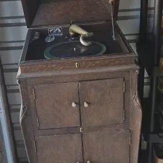 Antique Victor Victrola floor model record player in a dark wood cabinet with double doors and cabriole legs.