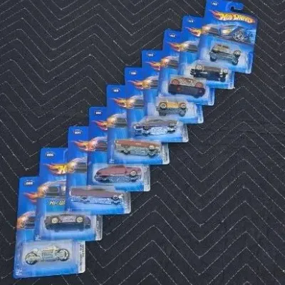 Collection of ten carded Hot Wheels die-cast toy vehicles, including cars and a motorcycle, from the early 2000s.
