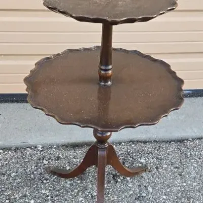 Vintage mahogany two-tier dumbwaiter table featuring piecrust edges and a tripod base with cabriole legs.