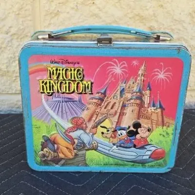 Vintage Walt Disney's Magic Kingdom metal lunchbox, circa 1980, featuring illustrations of Mickey Mouse, Donald Duck, Pluto, and a...