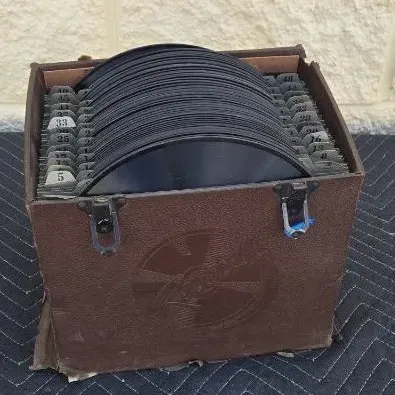 Vintage brown textured record carrying case filled with 78 RPM shellac records, featuring numbered index tabs.