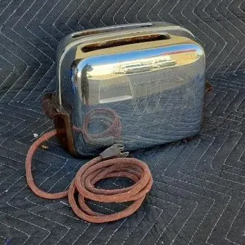 Vintage Sunbeam T-9 chrome two-slice toaster with etched wheat design and original cloth-covered power cord.