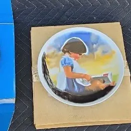 Three collectible porcelain plates, including a blue and white Bing & Grøndahl 1980 Christmas plate in its original box, a plate...