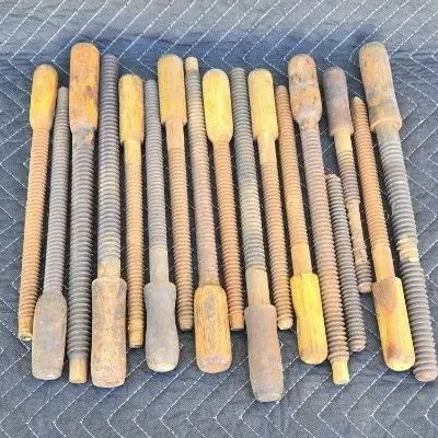 Collection of antique wooden vise screws and spindles, showing significant wear and age-related patina.