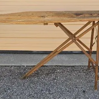 Vintage wooden folding ironing board with a rustic, weathered finish and sturdy cross-leg support structure.