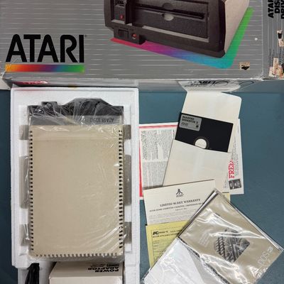 Sale Photo Thumbnail #7: Vintage Atari 1050 Disk Drive in its original box, complete with styrofoam packaging, power adapter, DOS 3 master diskette, and instruction manuals.