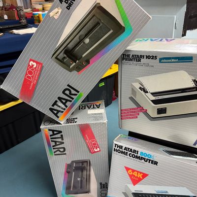 Sale Photo Thumbnail #4: Vintage Atari computer hardware in original boxes, including two Atari 1050 Disk Drives, an Atari 1025 Printer, and an Atari 800XL Home Computer, circa 1983.