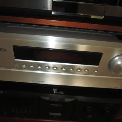 Onkyo THX-certified AV receiver in a silver finish, stacked with other home audio components.