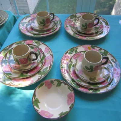 Franciscan Desert Rose pattern ceramic dinnerware set, including dinner plates, salad plates, cups, saucers, and a small bowl, displayed...