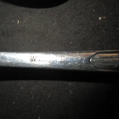 Close-up of a WMF silver-plated flatware handle, showing the maker's mark stamped into the metal.