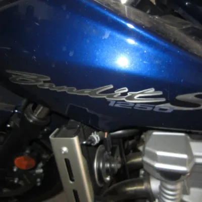 Suzuki Bandit 1250S motorcycle, featuring a metallic blue fairing with silver and blue model decals.