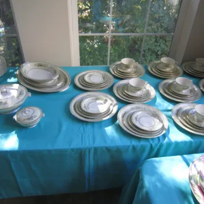 Vintage fine china dinnerware set with delicate floral patterns and gold trim, including plates, bowls, teacups, saucers, and serving...