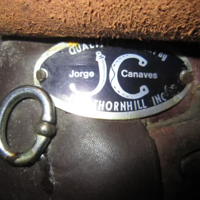 Jorge Canaves Thornhill leather saddle maker's mark plate, showing some wear and oxidation on the metal hardware.
