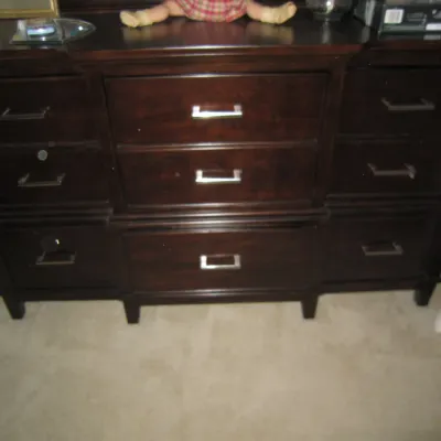 Contemporary dark espresso-finished wooden dresser featuring nine drawers with sleek silver-toned metal bar pulls.