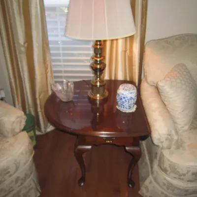 Traditional mahogany drop-leaf side table with cabriole legs, featuring a brass table lamp and decorative porcelain jar.