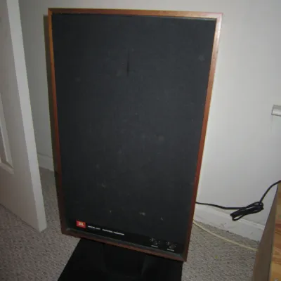 Vintage JBL Model 4311 Control Monitor speaker in a wood cabinet, mounted on a black pedestal stand.