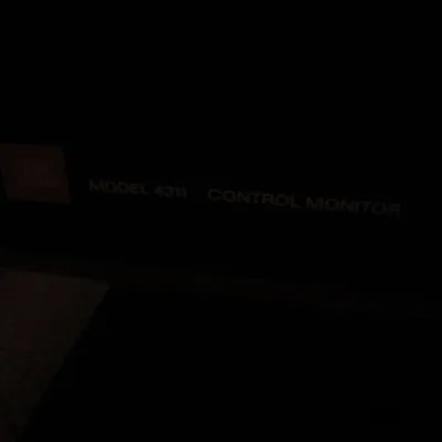 Vintage JBL Model 4311 Control Monitor speaker badge, showing the logo and model text on a dark cabinet.