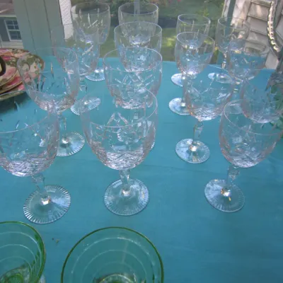 Collection of vintage cut crystal stemware in various sizes, featuring intricate geometric patterns and ribbed bases.