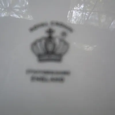 Out-of-focus maker's mark on the underside of a Royal Crown Staffordshire porcelain piece.