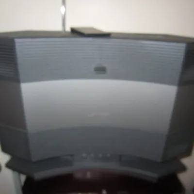 Bose Acoustic Wave music system II in graphite gray, complete with a remote control resting on top.
