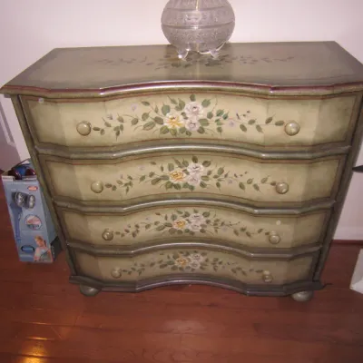 Vintage hand-painted serpentine chest of drawers featuring a sage green finish with floral motifs and four spacious drawers.