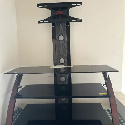 Z-Line Designs TV stand featuring three black tempered glass shelves, wood-look curved side supports, and an integrated mount, available...